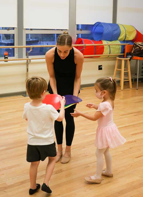 Early childhood teacher with two young students in class